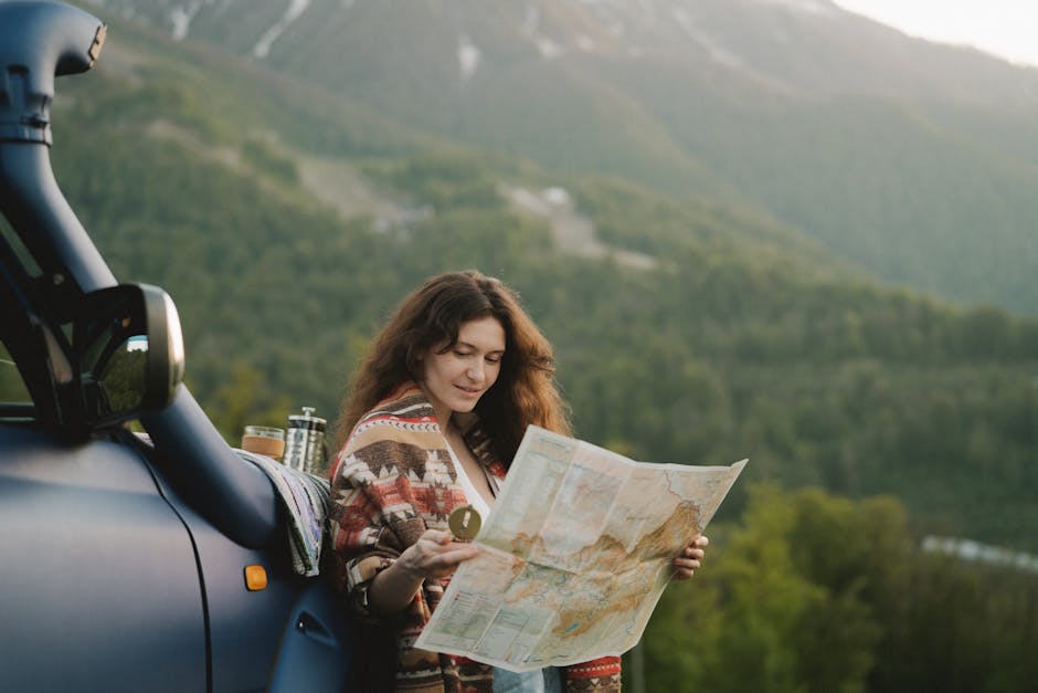 A woman enjoys a scenic mountain road trip, using a map to navigate picturesque landscapes.