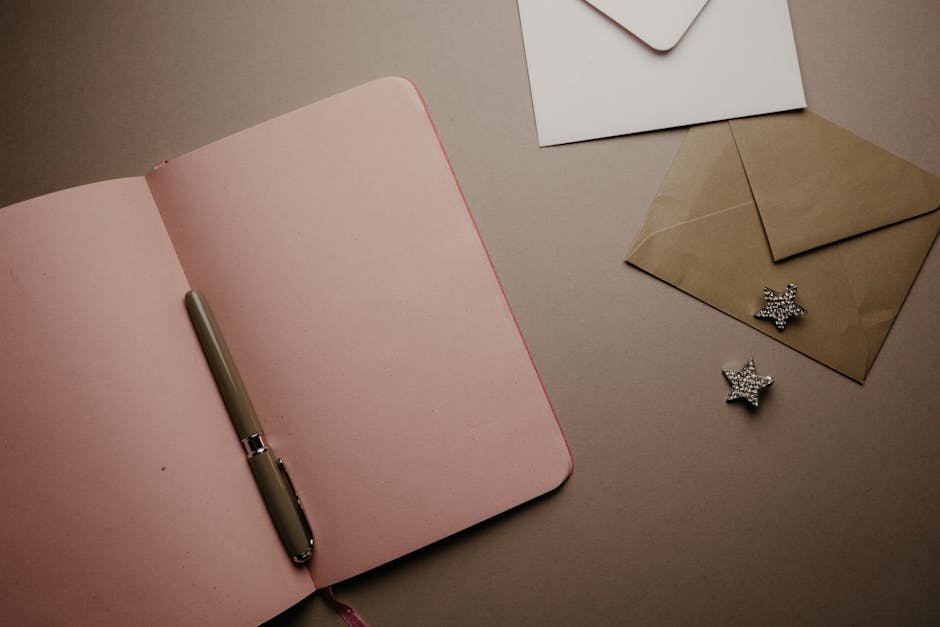 Aesthetic flat lay featuring an open pink notebook and envelopes, perfect for writing themes.