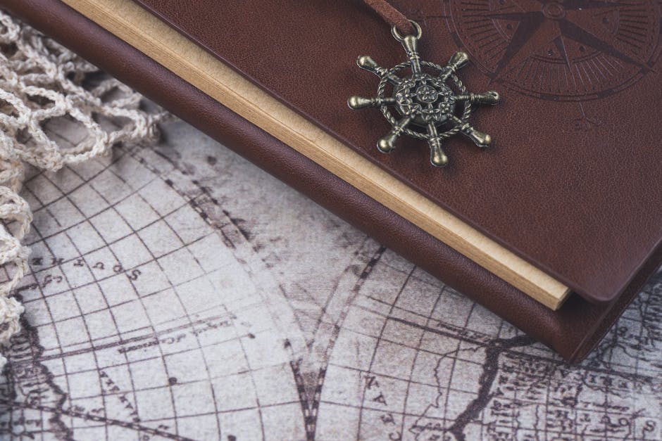 A vintage-style leather-bound journal with a nautical charm on an antique world map, evoking exploration.