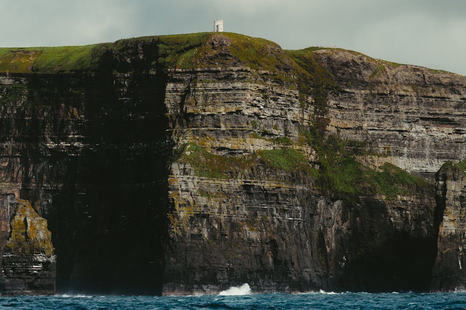 Dramatic cliffs of Inishmore, Ireland, with lush greenery and ocean view.