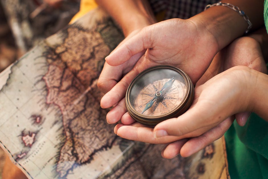 Close-up of hands holding a vintage compass over a map, symbolizing exploration.